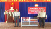 Đồng chí Nguyễn Văn Viết - TPTP (bên trái) trao tặng tủ sách cho nhân dân Ấp 6, xã Lộc Thái